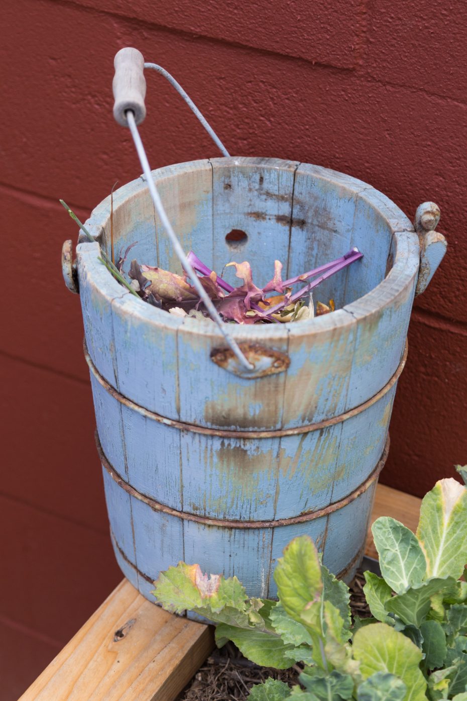 blue wood pail used to collect garden clippings