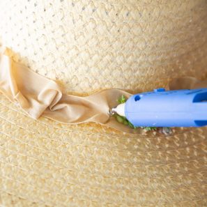 use hot glue to attach living succulents onto straw hat