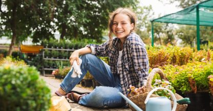 Adobe Stock Drobot Dean woman in garden smiling flowers watering can