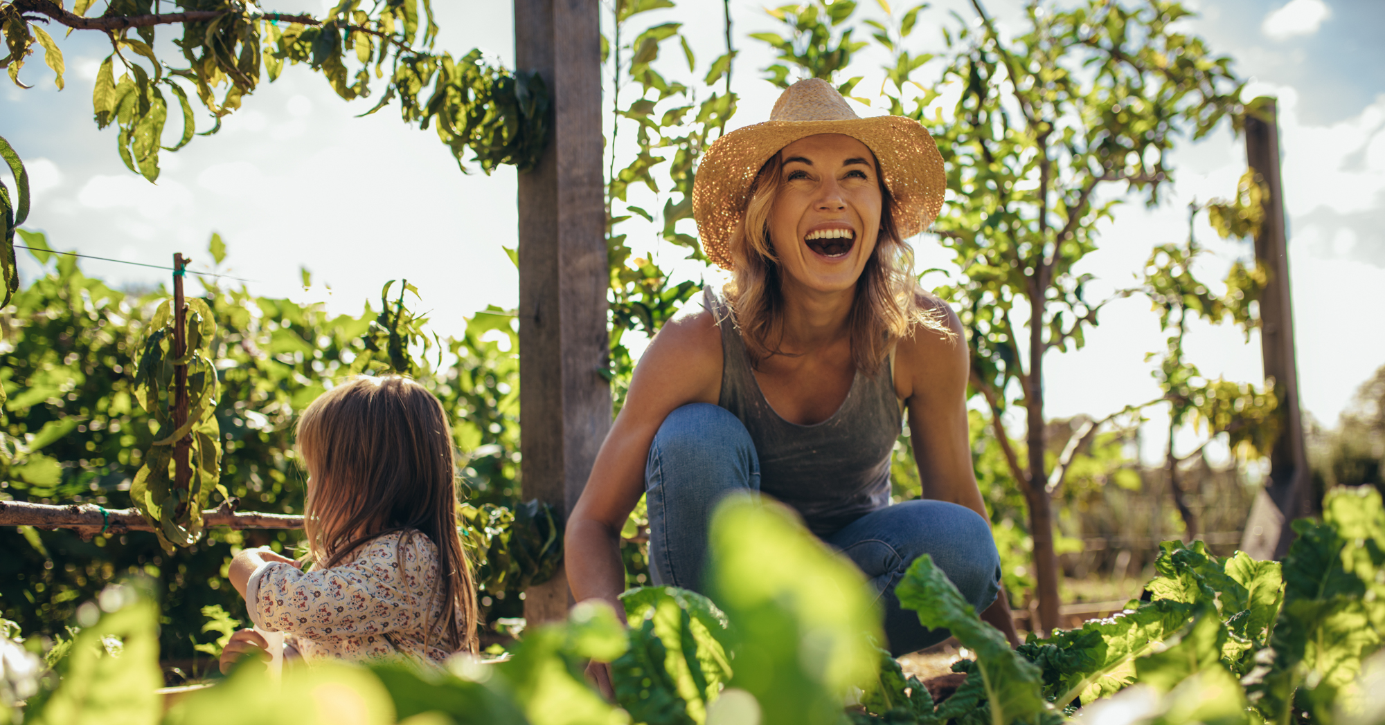 Adobe Stock Jacob Lund woman hat child smiling garden vegetables