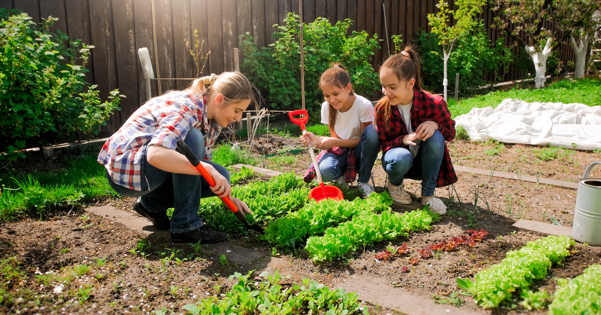 Adobe Stock Kirill Ryzhov mom daughters girls woman planting vegetables row garden