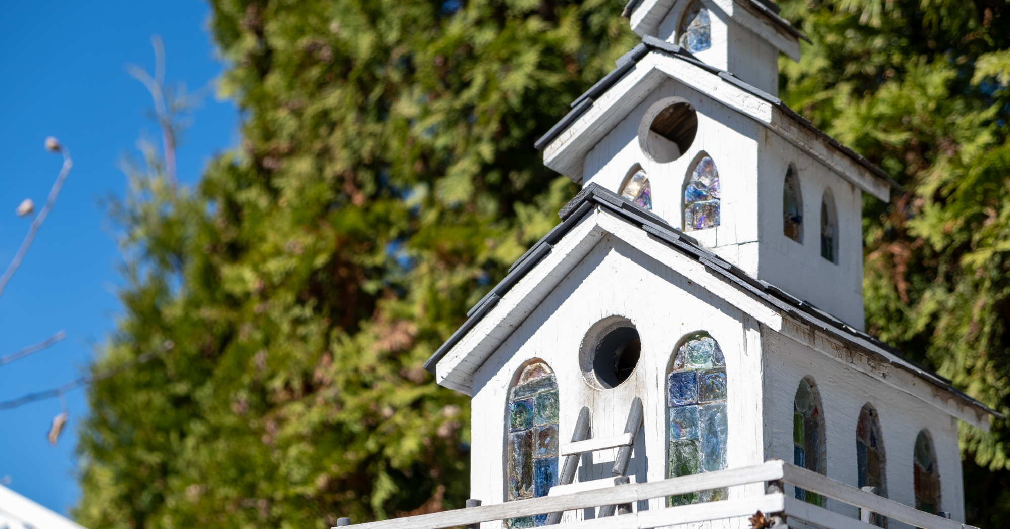 Adobe Stock SpencerV17 church shaped birdhouse unique glass windows white