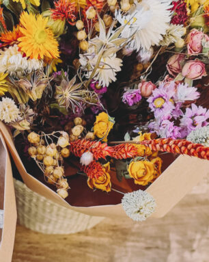 Vibrant dried flower arrangement in red, yellow and purples on a